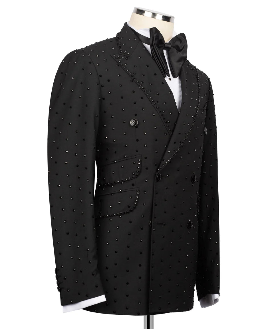 A black double-breasted tuxedo jacket embellished with small silver studs, displayed on a mannequin with a black bow tie and white shirt against a white background.