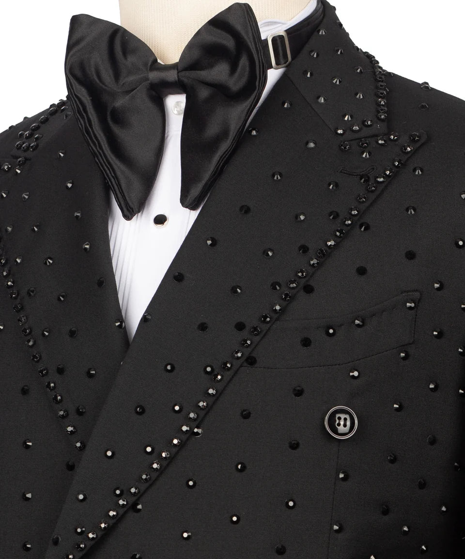 A close-up of a black tuxedo jacket with silver rhinestone embellishments, a matching black satin bow tie, and a white pleated dress shirt on a mannequin.