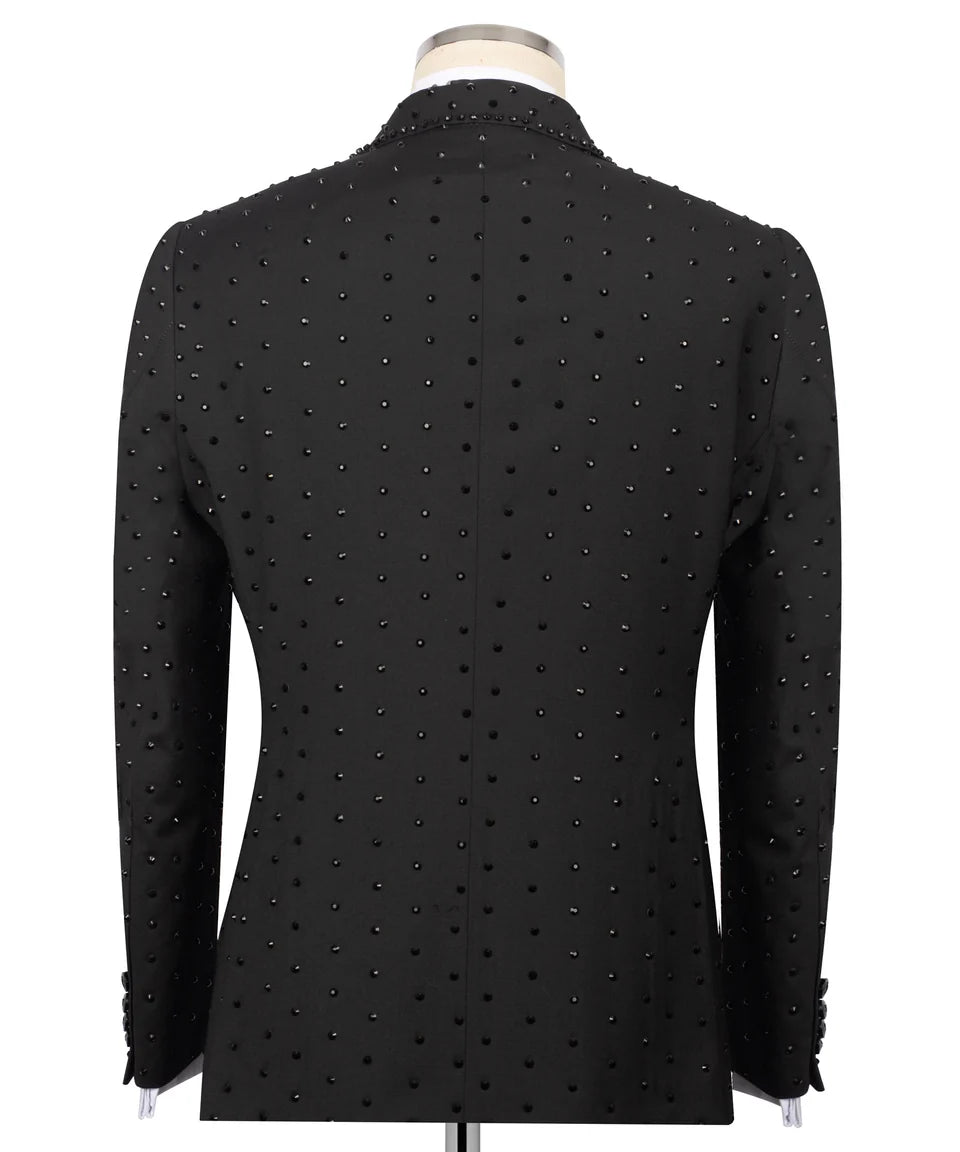 Black long-sleeve blazer jacket with a high collar, decorated with rows of small silver studs and rhinestones, shown on a mannequin from the back.