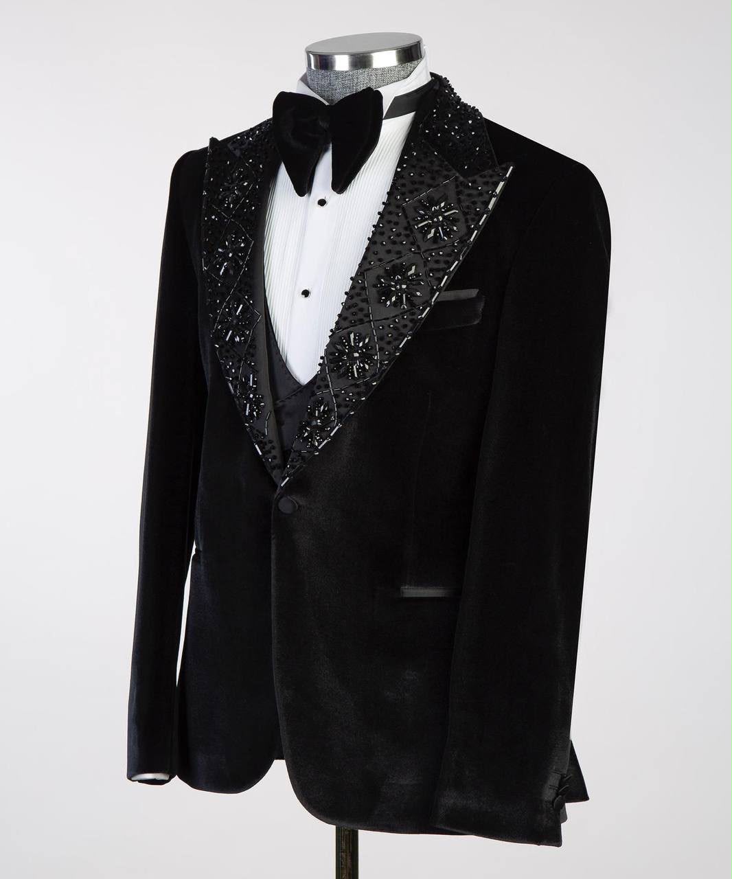 Black tuxedo with decorative lapels on a mannequin against a white background