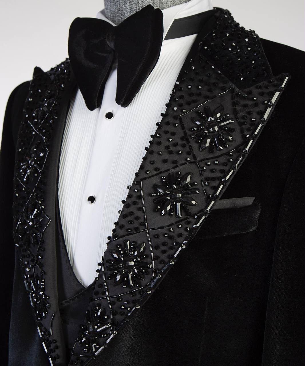 Black tuxedo with decorative lapels on a mannequin against a white background