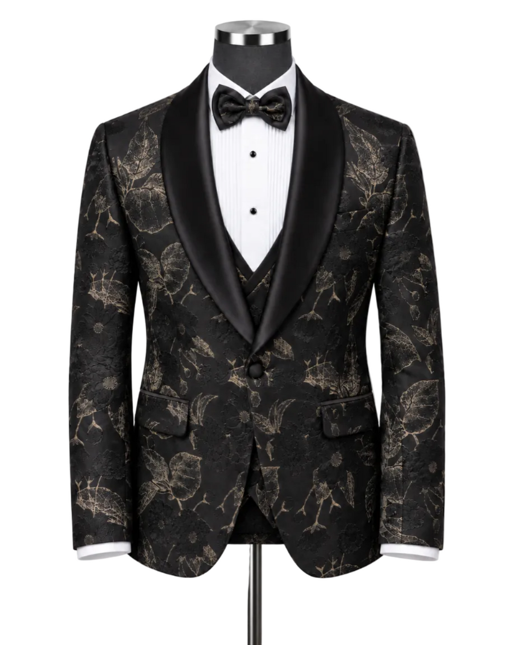 A men's tuxedo jacket displayed on a mannequin torso, featuring a black and gold floral brocade pattern with black satin shawl lapels, styled with a white pinstripe shirt, black bow tie, and matching vest.