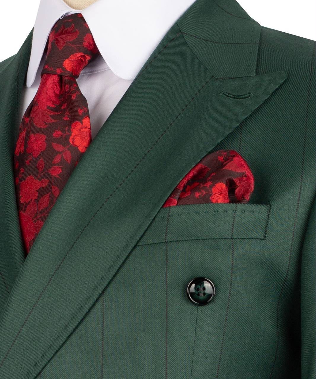 A close-up of a men's formal outfit featuring a dark forest green double-breasted suit jacket with thin vertical pinstripes, paired with a white dress shirt, a red and black floral patterned tie, and a matching pocket square.