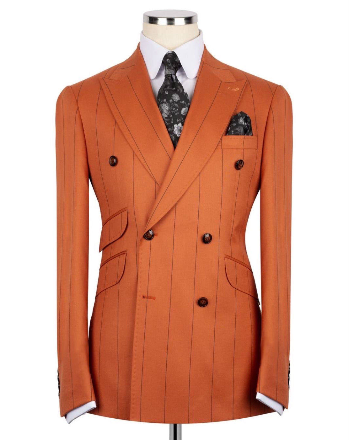 Orange double-breasted suit jacket on a mannequin with a white shirt and patterned tie.