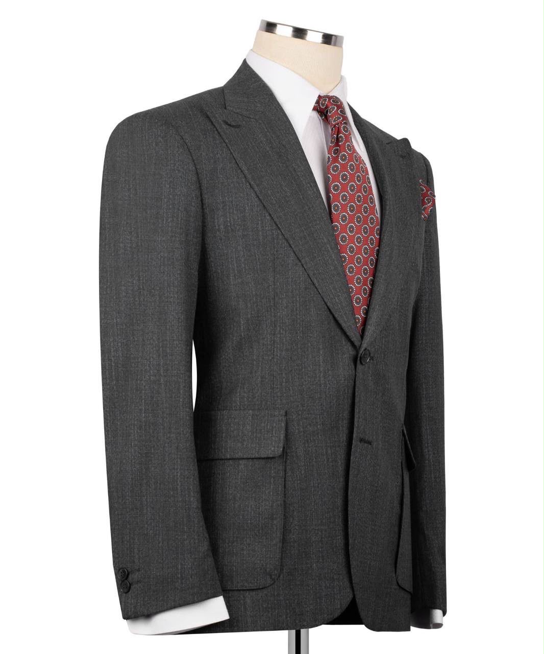 A dark gray textured wool suit jacket displayed on a mannequin torso, styled with a white dress shirt, a red and black patterned tie, and a matching pocket square.