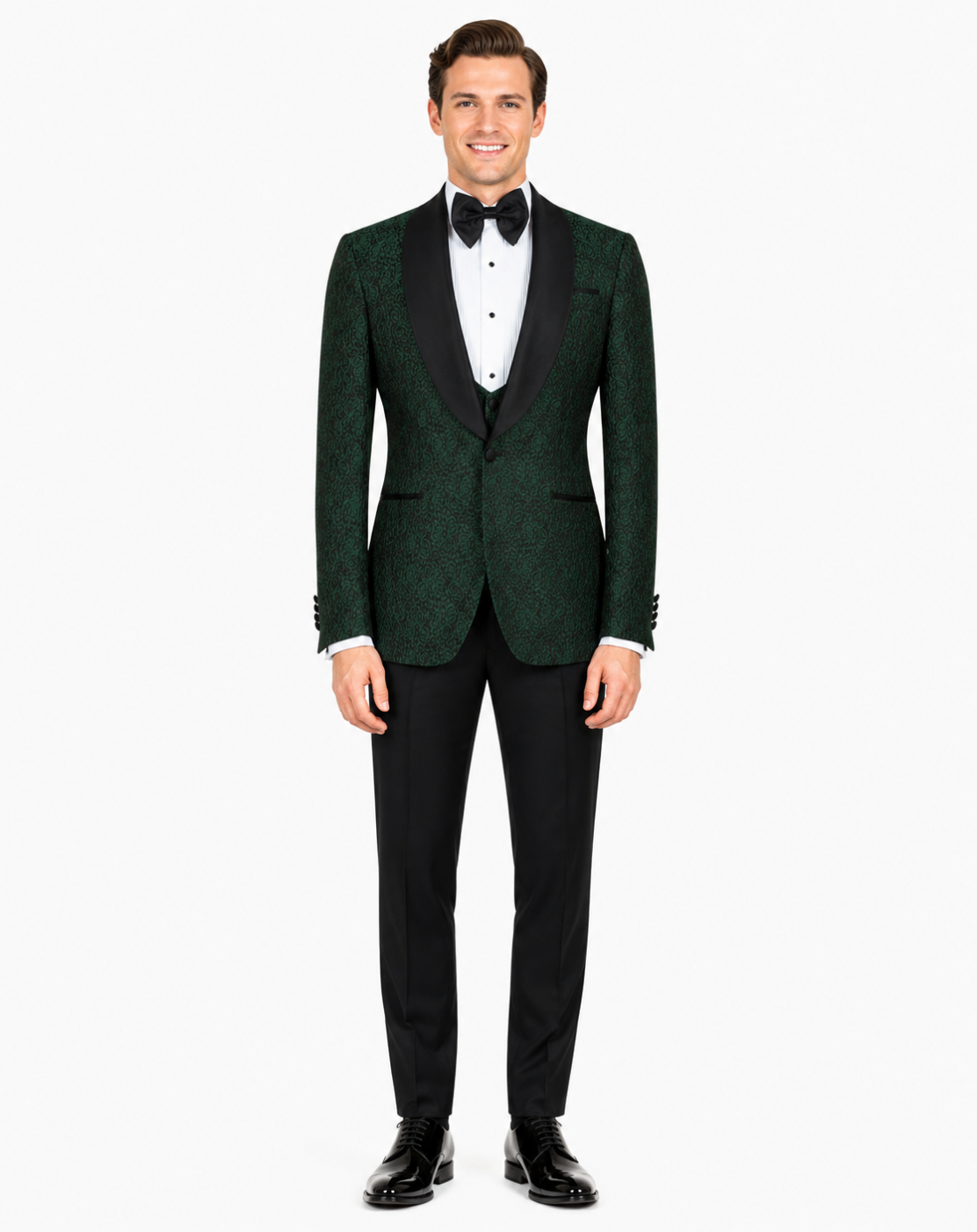 A man modeling a dark green textured tuxedo jacket with black satin lapels, paired with black trousers, a white dress shirt, and a black bow tie