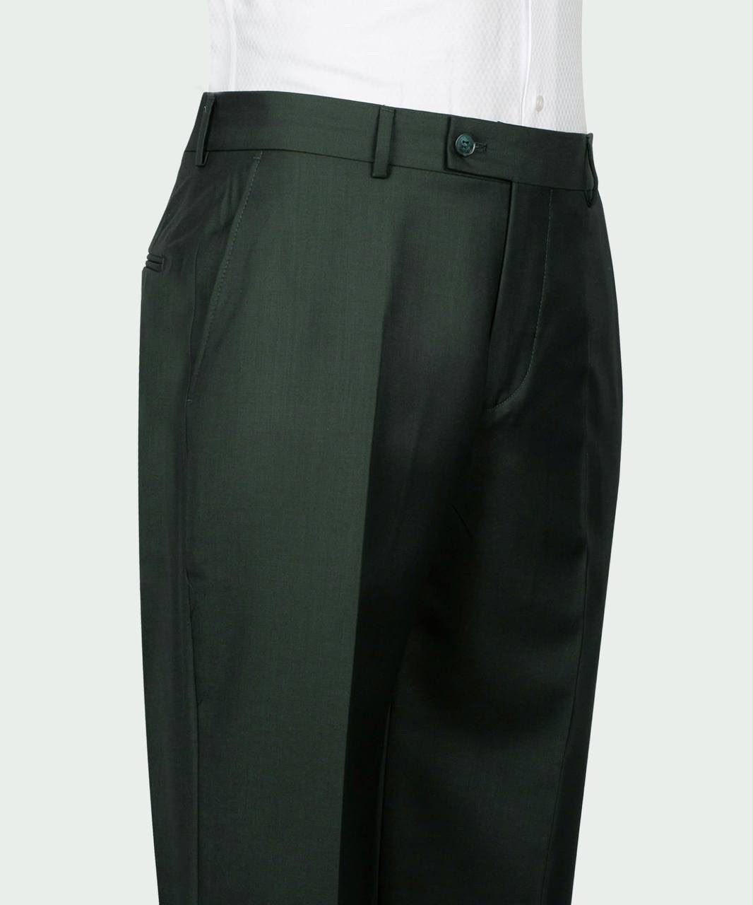 A close-up of dark green tailored trousers worn with a white shirt, showing the waistband, belt loops, front pockets, and front pleats 
