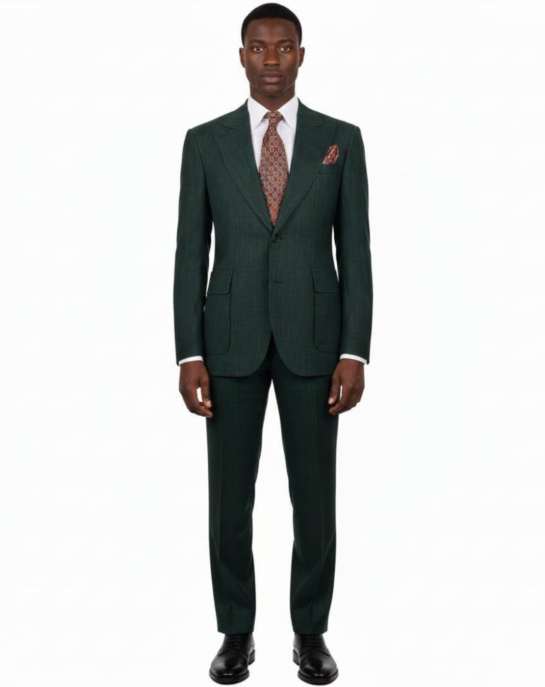 A man modeling a dark green pinstripe suit with a white dress shirt, a patterned brown tie, and a matching pocket square, shot against a solid white background.