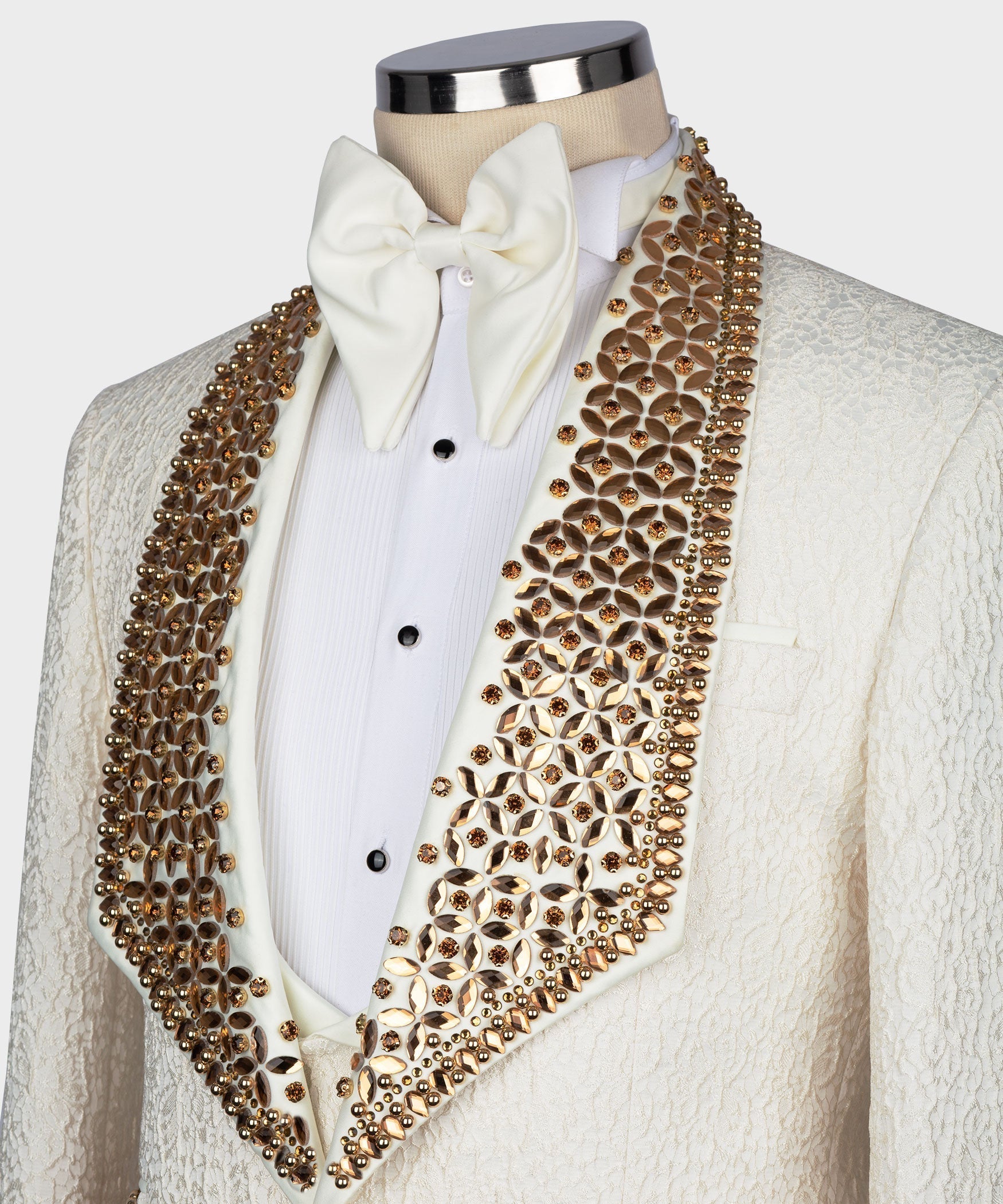 Gold jeweled shawl lapel on white tuxedo jacket with bow-tied shirt