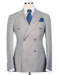 A light gray double-breasted suit jacket with a subtle micro-check pattern, displayed on a mannequin torso with a white dress shirt, blue patterned tie, and matching pocket square.