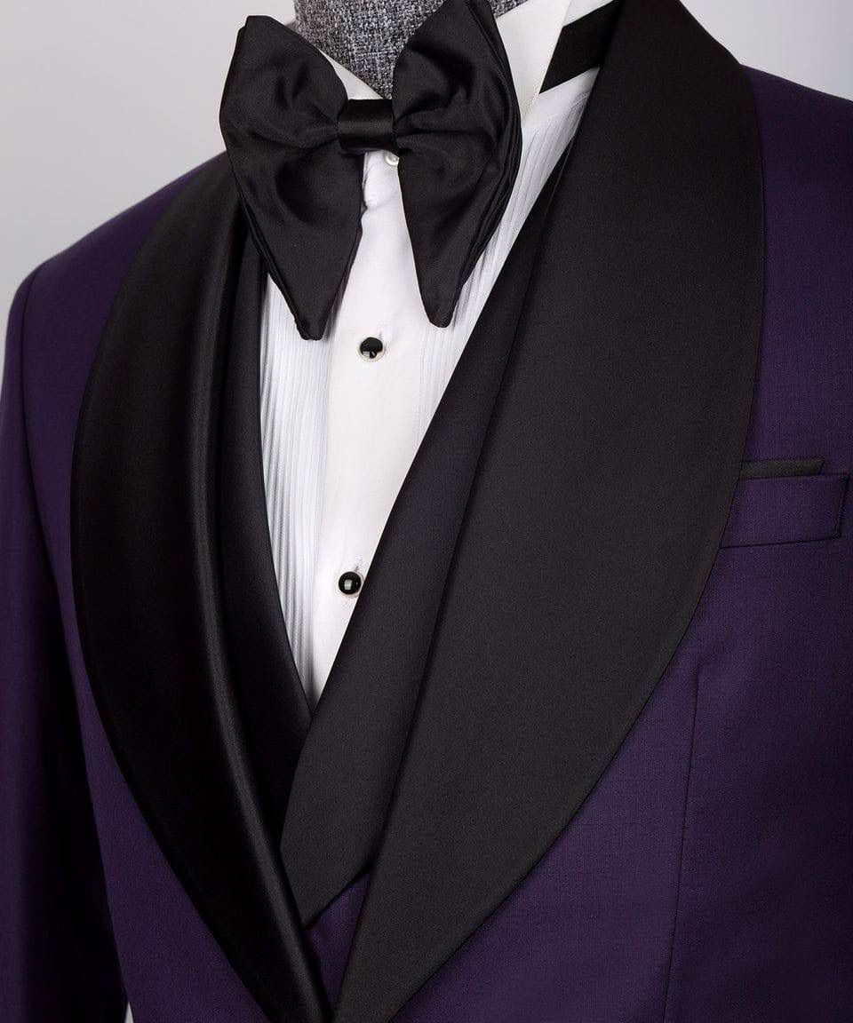 Purple tuxedo with black bow tie and lapels on a mannequin against a gray background