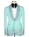 A mint green tuxedo jacket with sparkling rhinestone embellishments, styled on a mannequin with a white shirt, black bow tie, and a matching rhinestone-trimmed collar.
