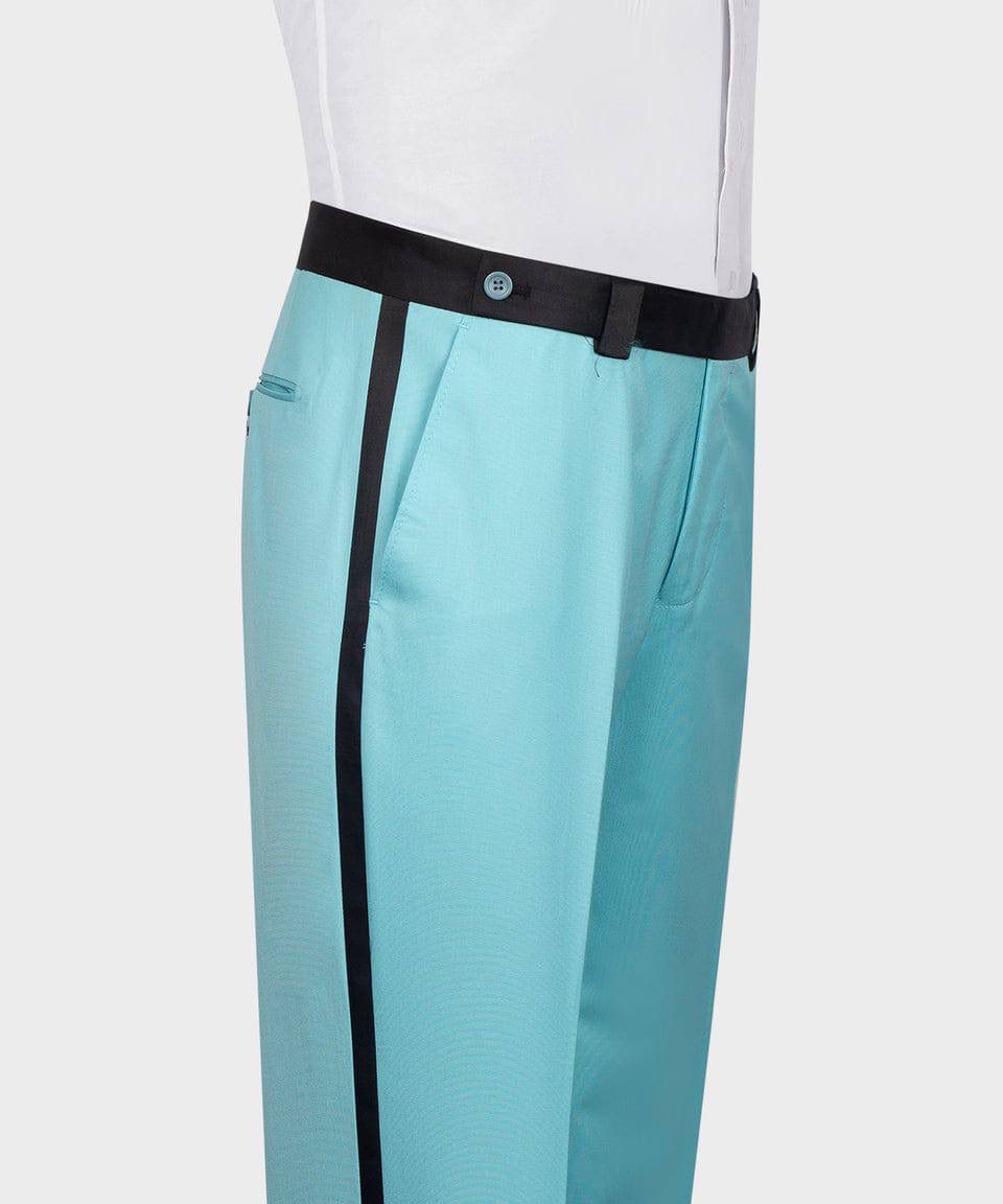 A close-up of a person wearing turquoise trousers with a black side stripe, a black waistband, and a white shirt tucked in, shown against a light gray background.