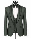 A dark forest green three-piece tuxedo set displayed on a mannequin, featuring a single-breasted jacket with satin shawl lapels, a matching vest, a white dress shirt, a dark green bow tie, and a matching green waistcoat.