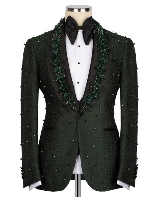 A dark green textured tuxedo jacket with green bead and sequin embellishments, displayed on a mannequin with a black bow tie and white shirt.
