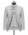 A light gray three-piece formal suit displayed on a mannequin, featuring a jacket with decorative dark buttons, a matching patterned vest, a patterned tie, and a white dress shirt.