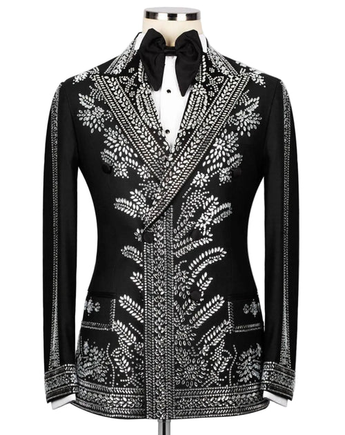 A black tuxedo jacket with intricate silver beadwork and embroidery, styled on a mannequin with a white shirt and black bow tie against a light gray background.
