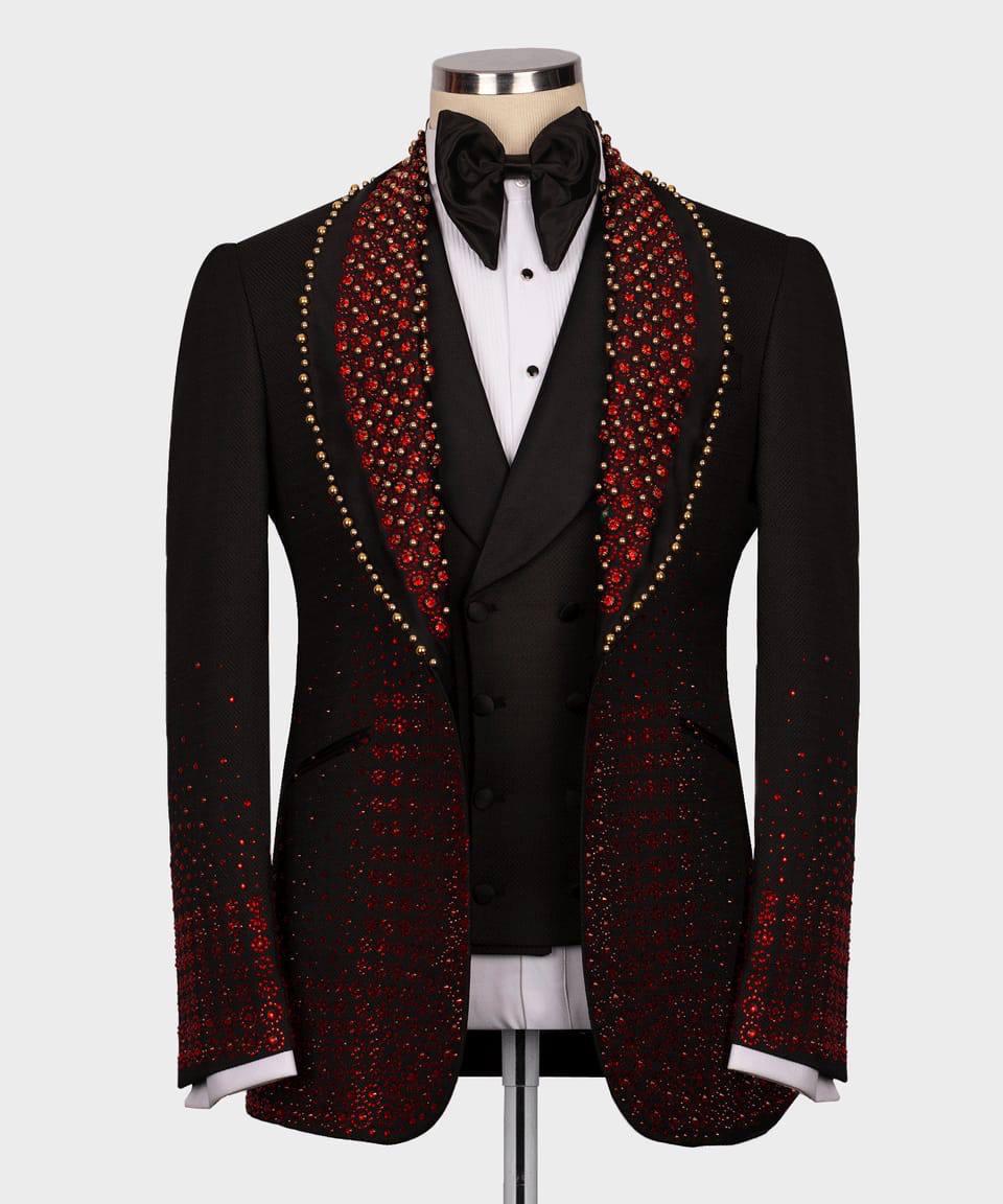 Black tuxedo with red and gold embellishments on a mannequin against a white background