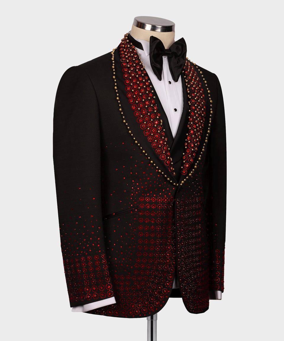 Black tuxedo with red and gold embellishments on a mannequin against a white background