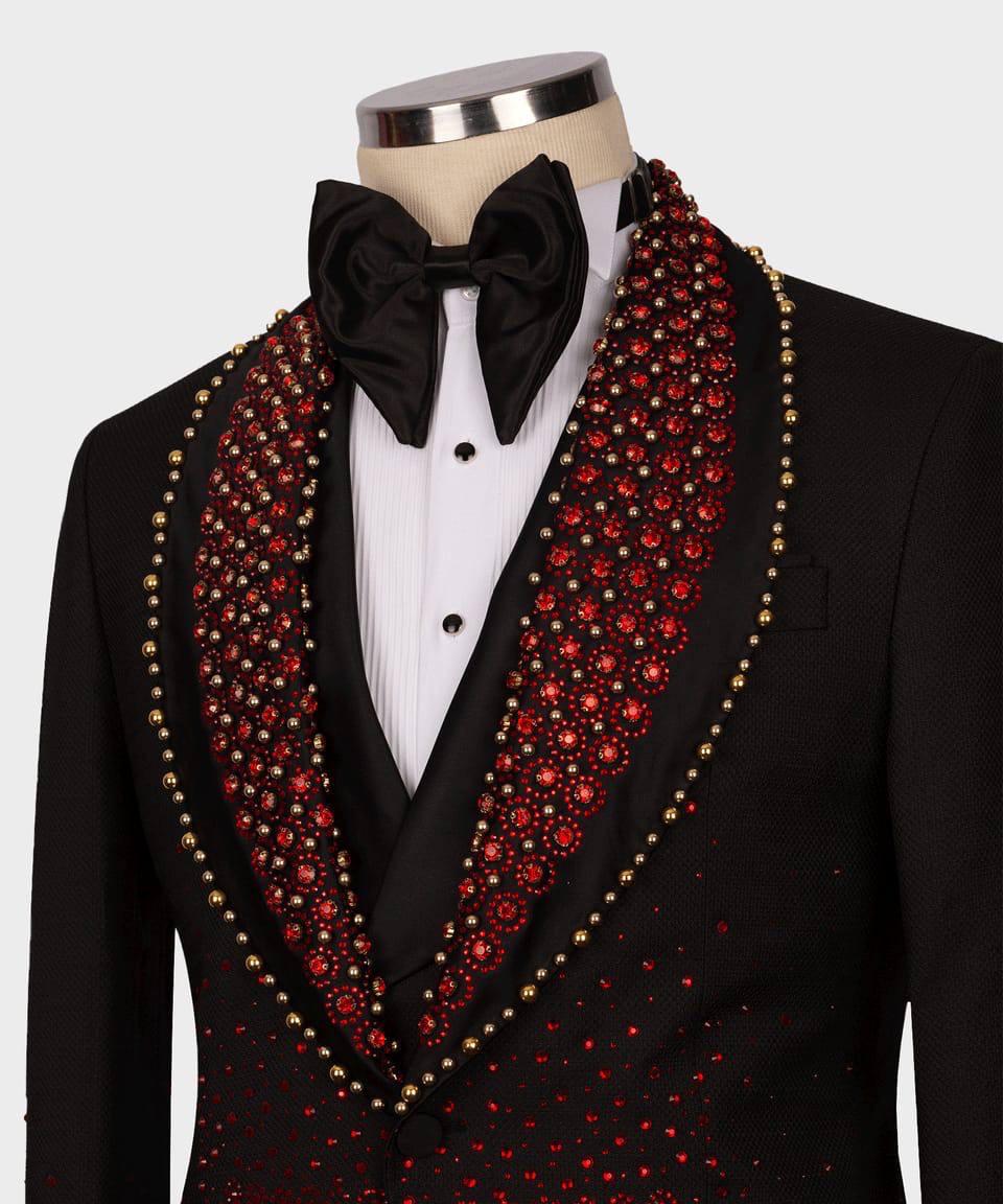 Black tuxedo with a red and gold embellished lapel on a mannequin against a white background