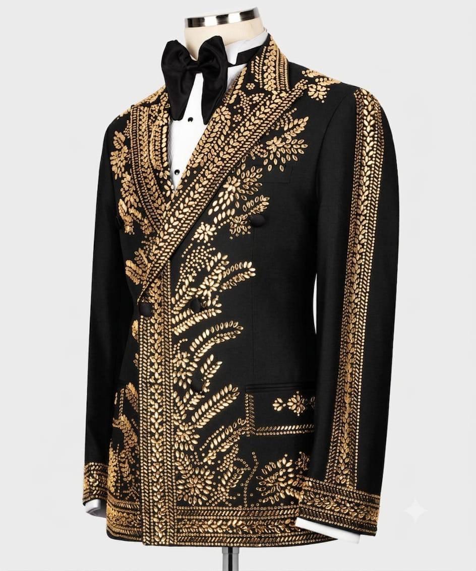 A black formal blazer jacket with elaborate gold embroidered floral and scroll patterns, displayed on a mannequin with a black bow tie and white shirt against a light gray background.