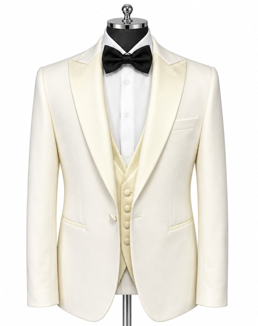 An ivory tuxedo jacket with satin peak lapels, displayed on a mannequin torso with a matching ivory vest, white dress shirt, black bow tie, and a silver stand against a white background.