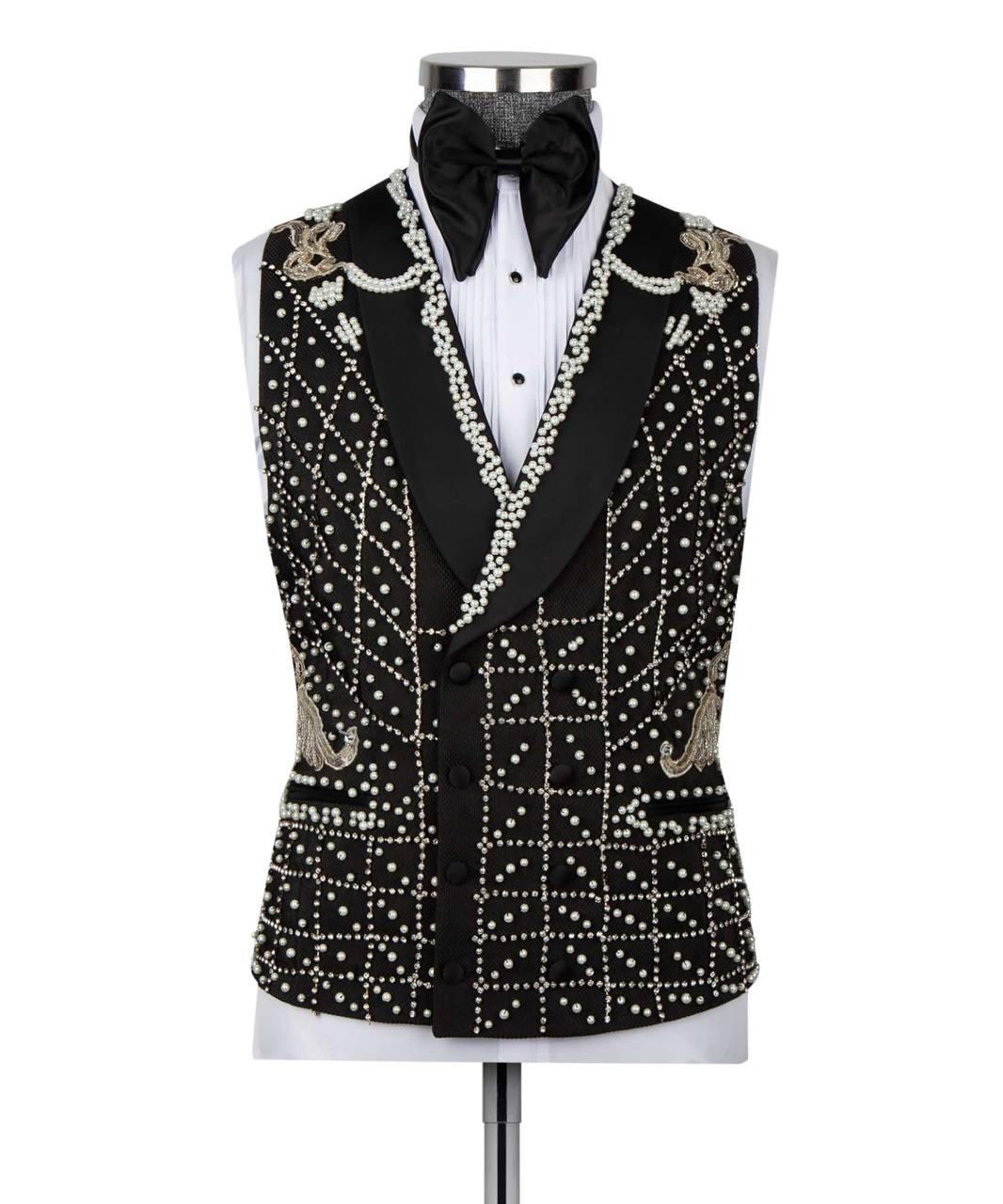 A black tuxedo vest with extensive white bead and pearl embellishments, styled on a white tuxedo shirt and black bow tie mannequin against a white background.