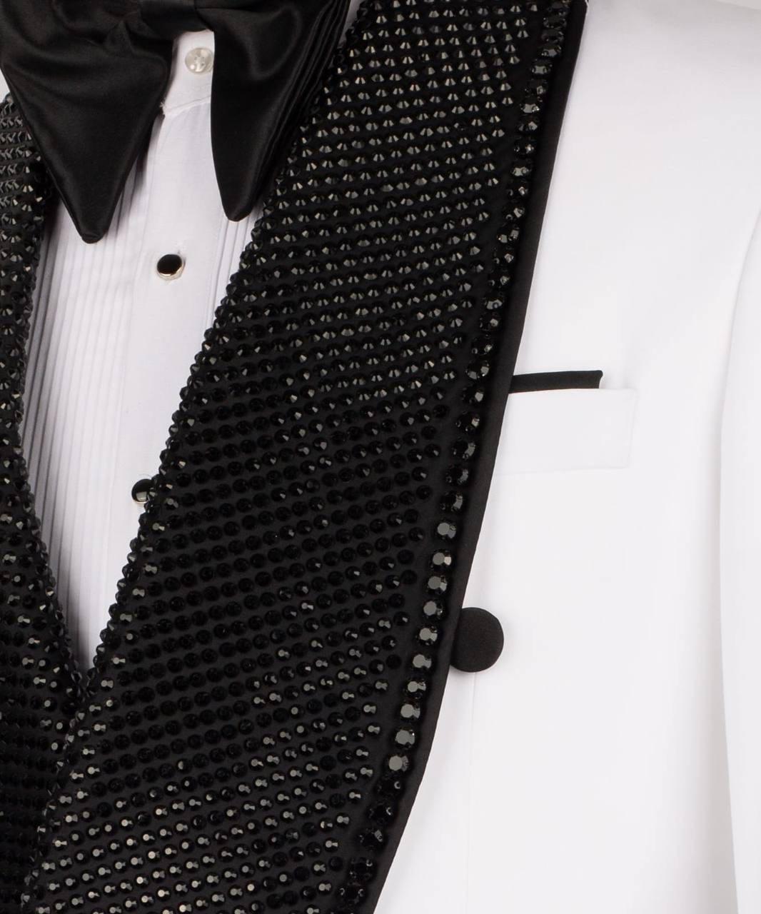 Close-up of a formal tuxedo jacket with a black sequined shawl lapel over a white pinstripe shirt and black satin bow tie.