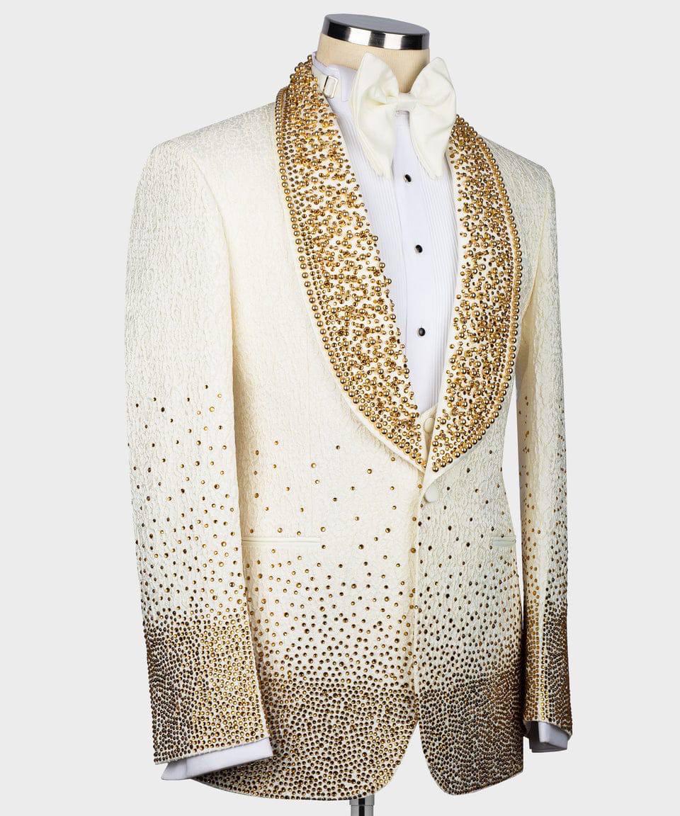 A white tuxedo jacket with gold sequined trim and a gradient of gold rhinestones fading from the shoulders to the cuffs and hem, displayed on a mannequin with a white shirt and bow tie.