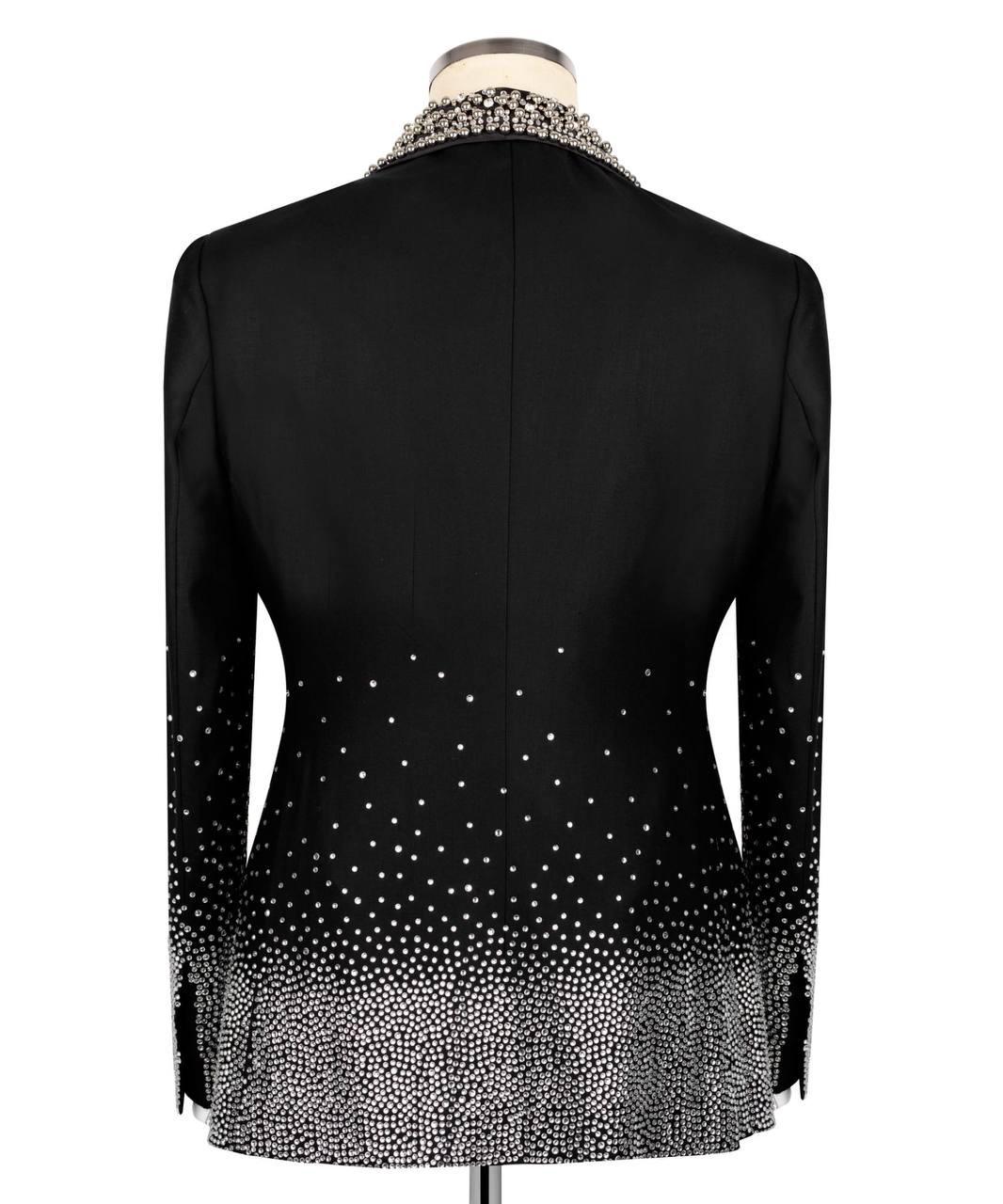 Black long-sleeve blazer shown from the back on a mannequin, featuring a beaded collar and a sparkling gradient pattern that fades from dense at the hem and cuffs to sparse near the shoulders.