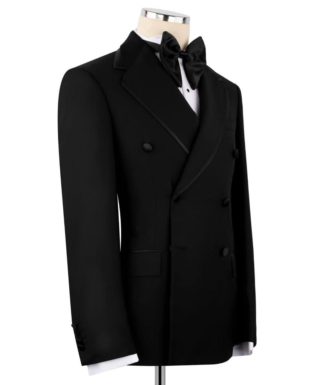 Black double-breasted coat on a mannequin with a white shirt and bow tie against a white background