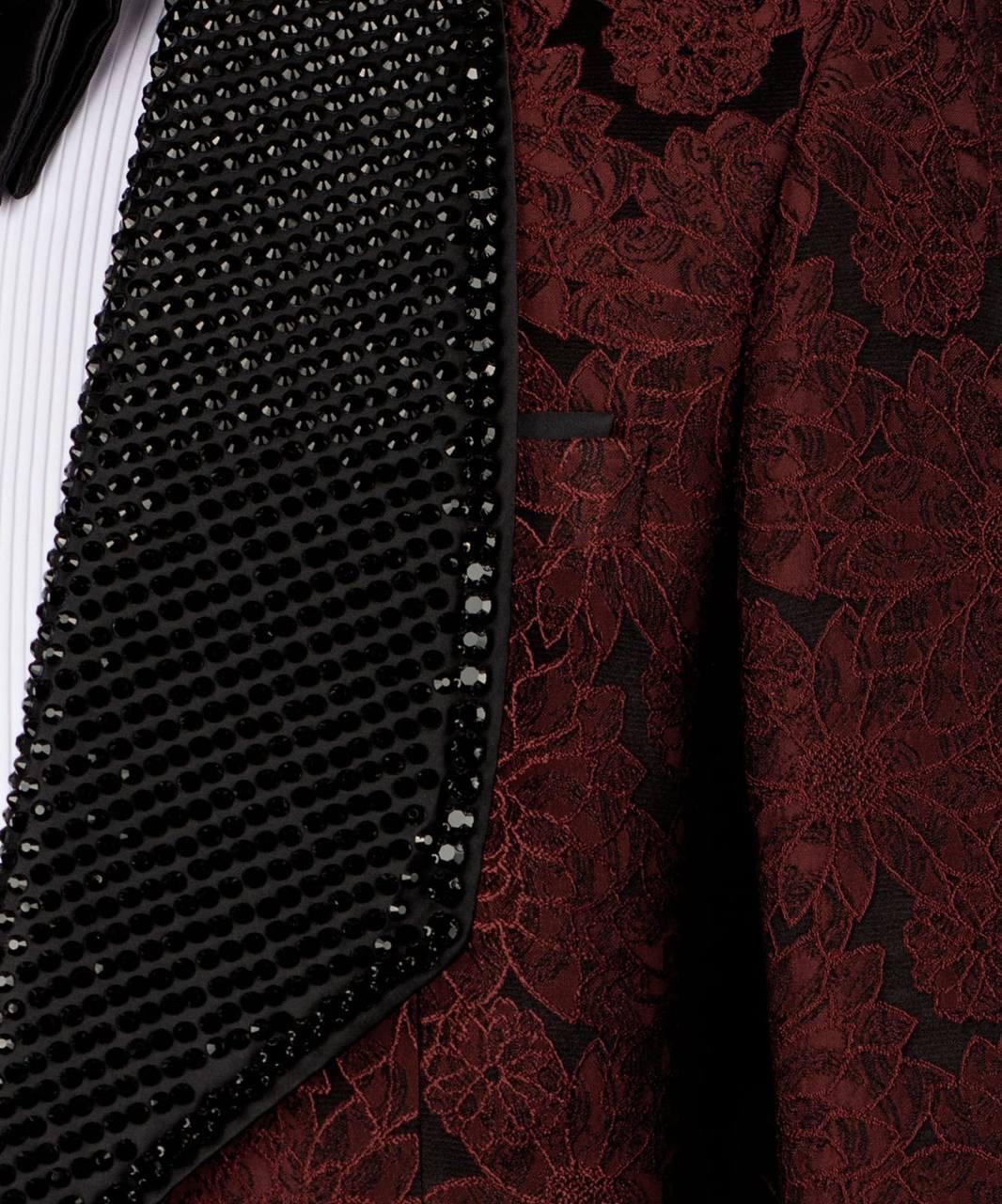 Close-up of black beaded fabric and red floral lace fabric.