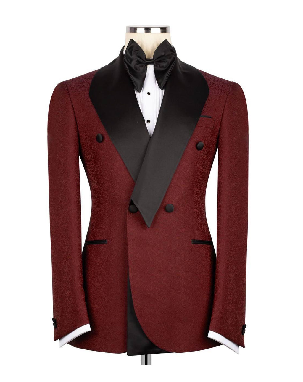 A men's double-breasted tuxedo jacket in a textured burgundy fabric with black satin peak lapels, displayed on a mannequin torso with a black bow tie, white dress shirt, and white cufflinks against a plain white background.