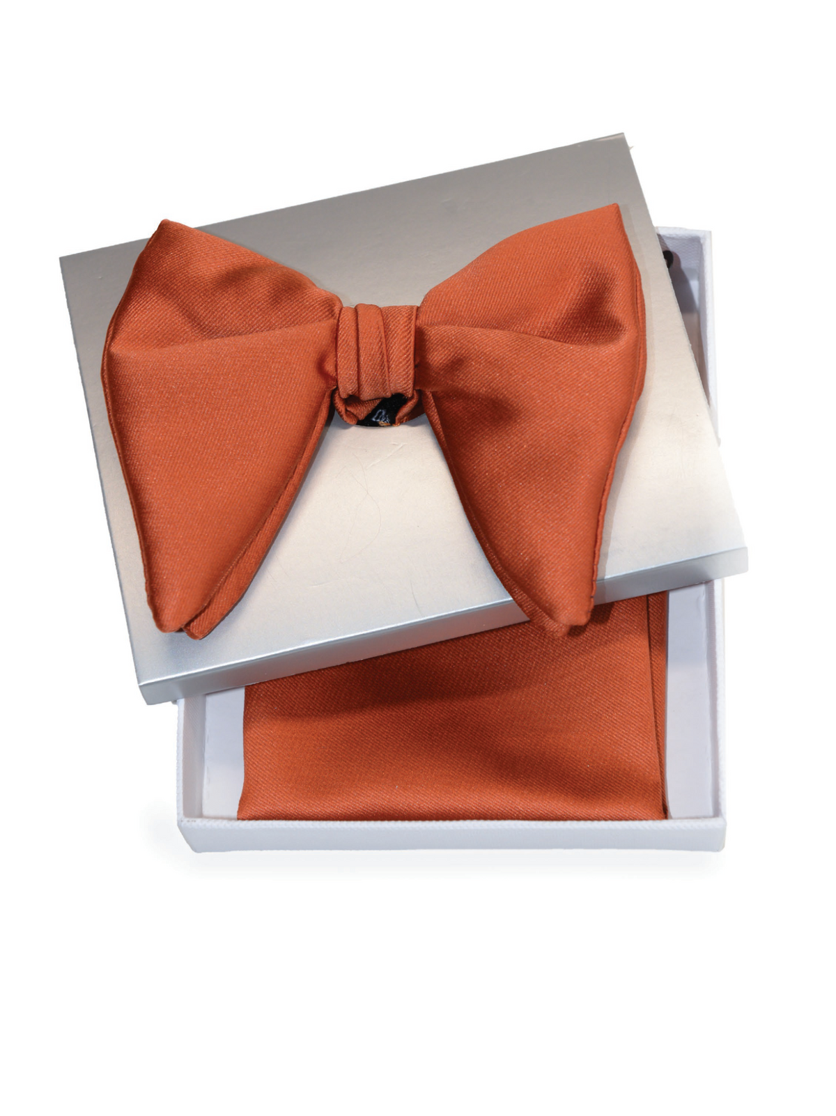 An orange satin bow tie presented in an open white gift box with a matching orange pocket square underneath.