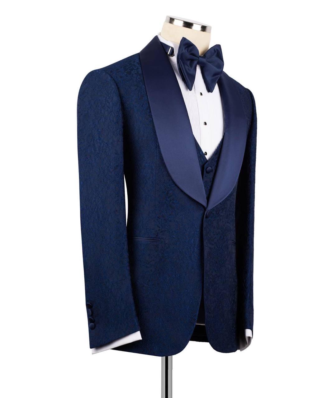 Navy blue tuxedo on a mannequin with a white shirt and bow tie against a white background
