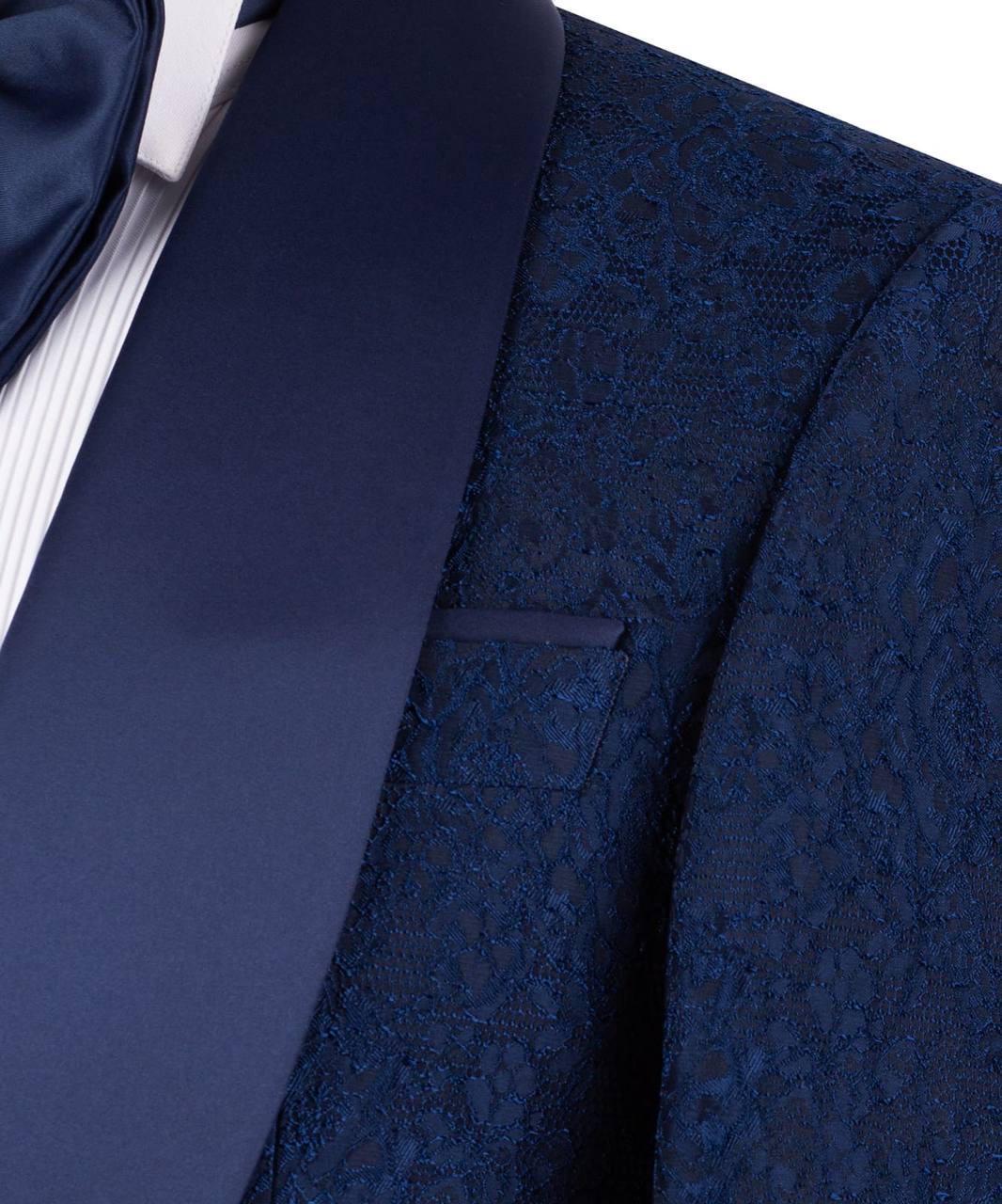 Close-up of a blue patterned suit jacket with a tie and shirt collar.