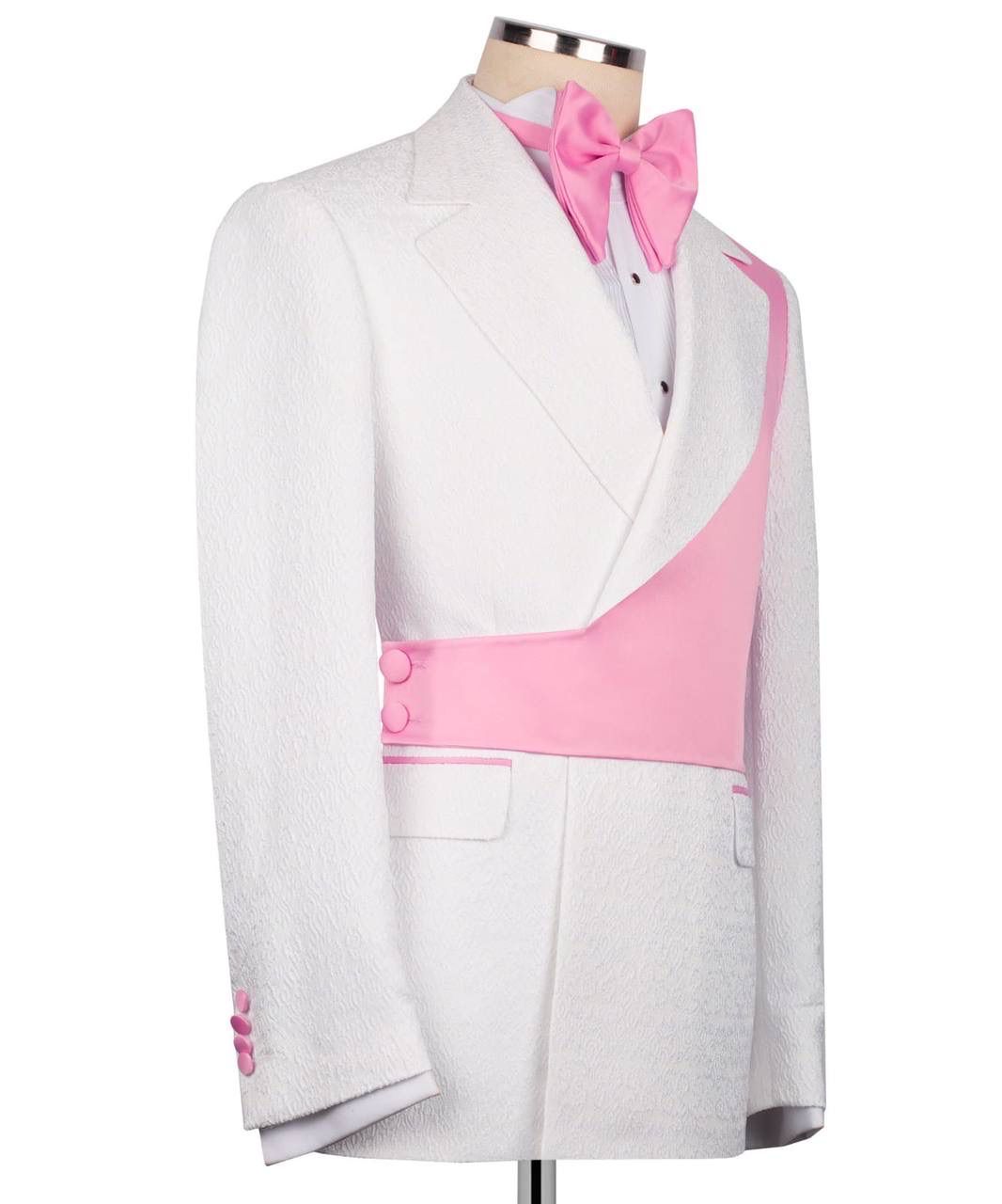 A white tuxedo jacket with vibrant pink contrast panels, a matching pink bow tie, and a white dress shirt, displayed on a mannequin torso against a white background.