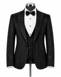 A men's black textured tuxedo jacket displayed on a mannequin with a white pinstripe shirt, black vest, black bow tie, and black trousers against a plain white background.