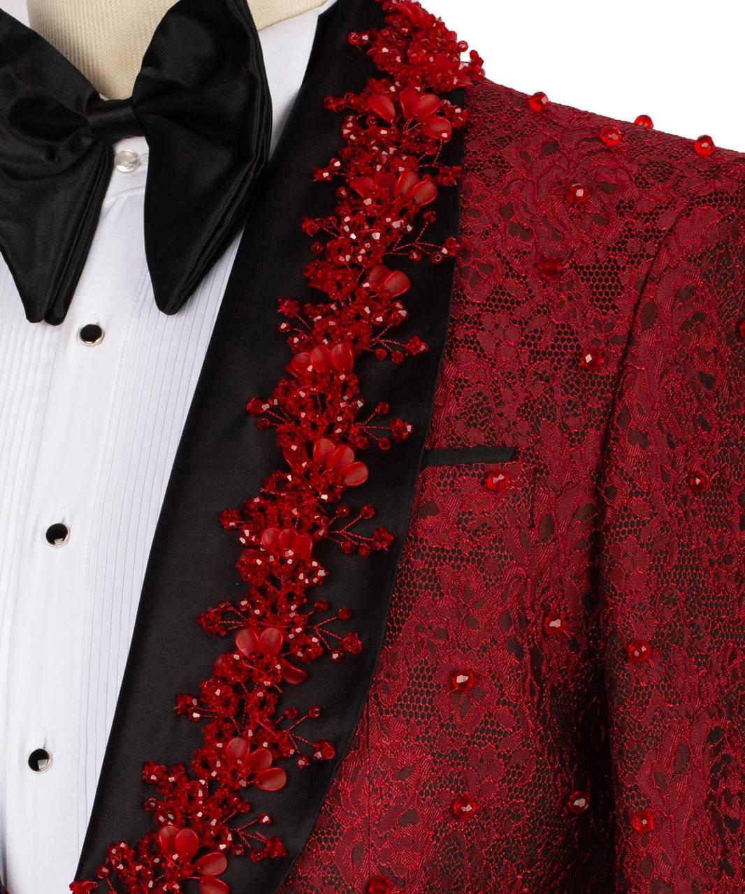 A close-up of a formal tuxedo jacket featuring a deep red lace overlay with red floral beadwork and embellishments, paired with a black satin lapel and a black bow tie over a white pinstripe shirt.