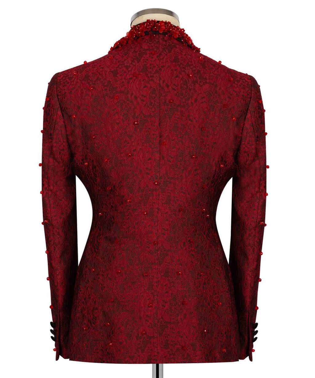 A dark red textured jacket with intricate floral lace patterns and beaded trim along the collar and cuffs, displayed on a mannequin against a white background.