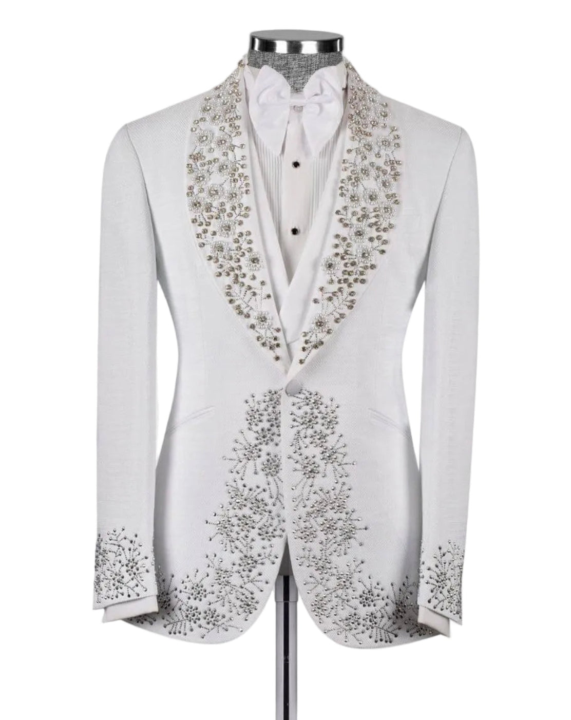 A white tuxedo jacket with elaborate silver and gold floral beadwork on the shawl collar and front panels, displayed on a mannequin with a white shirt and bow tie against a light gray background.