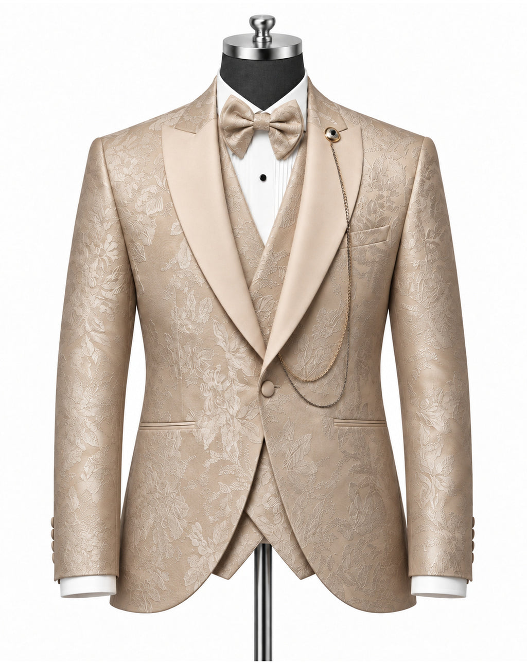 A men's formal tuxedo jacket with matching waistcoat and bow tie, displayed on a mannequin. The fabric is a champagne beige with a subtle floral damask pattern.