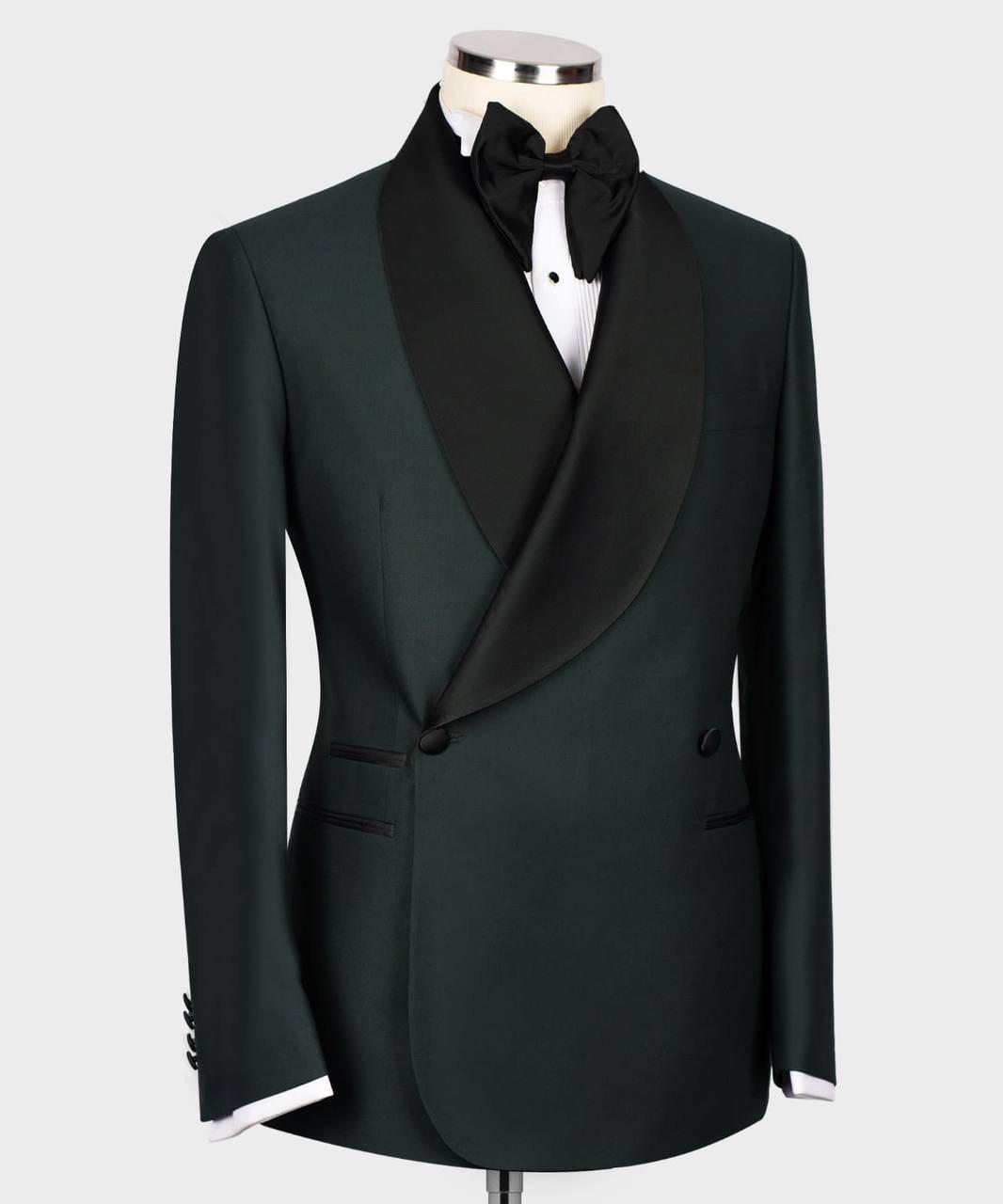 A dark forest green tuxedo jacket with black satin shawl lapels, styled on a mannequin with a black bow tie and white shirt collar visible, against a light gray background.