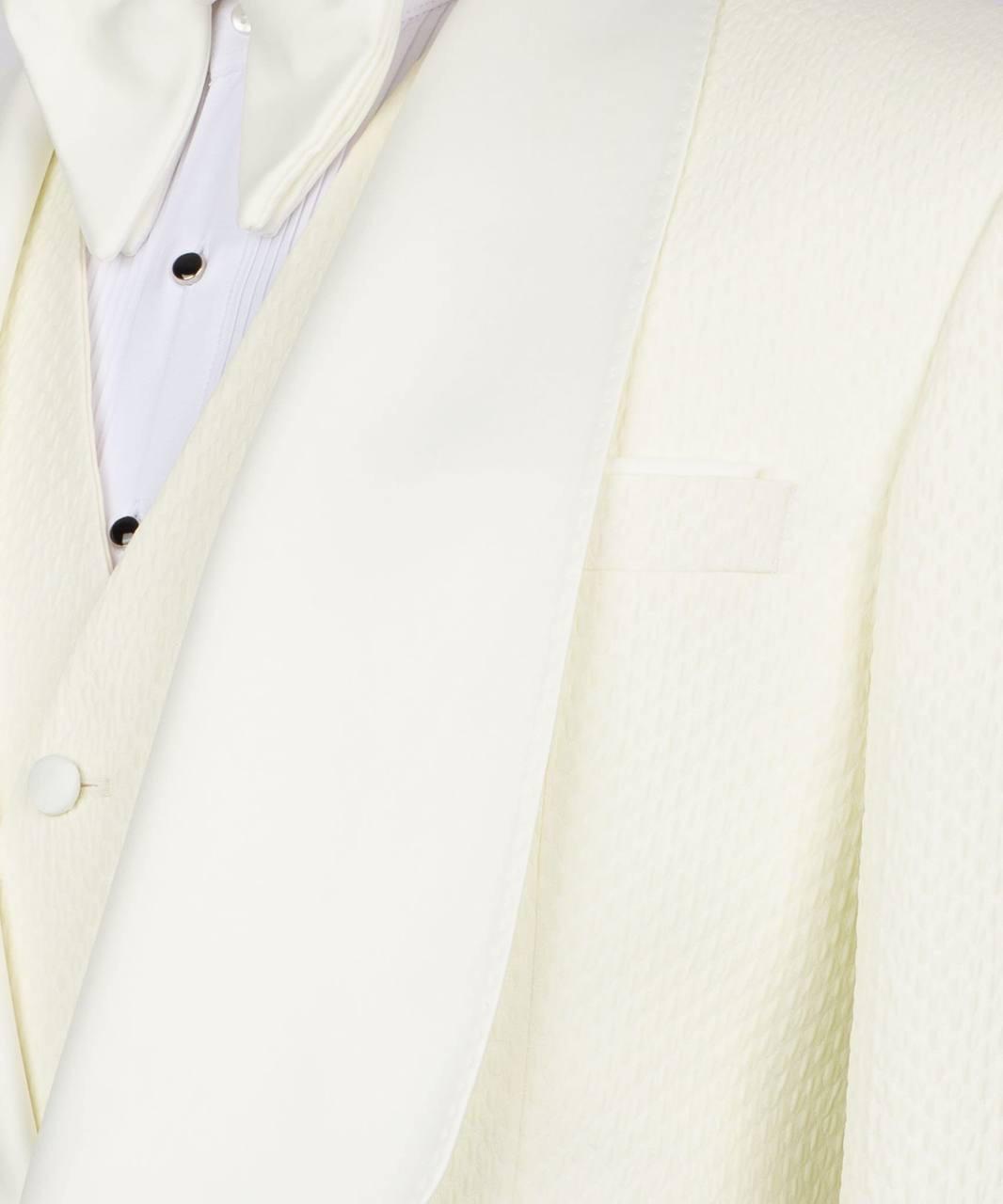 Close-up of a formal white or ivory tuxedo jacket with satin peak lapels, worn over a matching vest and a white pinstriped shirt with black buttons.
