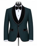 A men's formal tuxedo jacket in dark green with black velvet shawl lapels, displayed on a mannequin with a white dress shirt, black bow tie, and black vest.