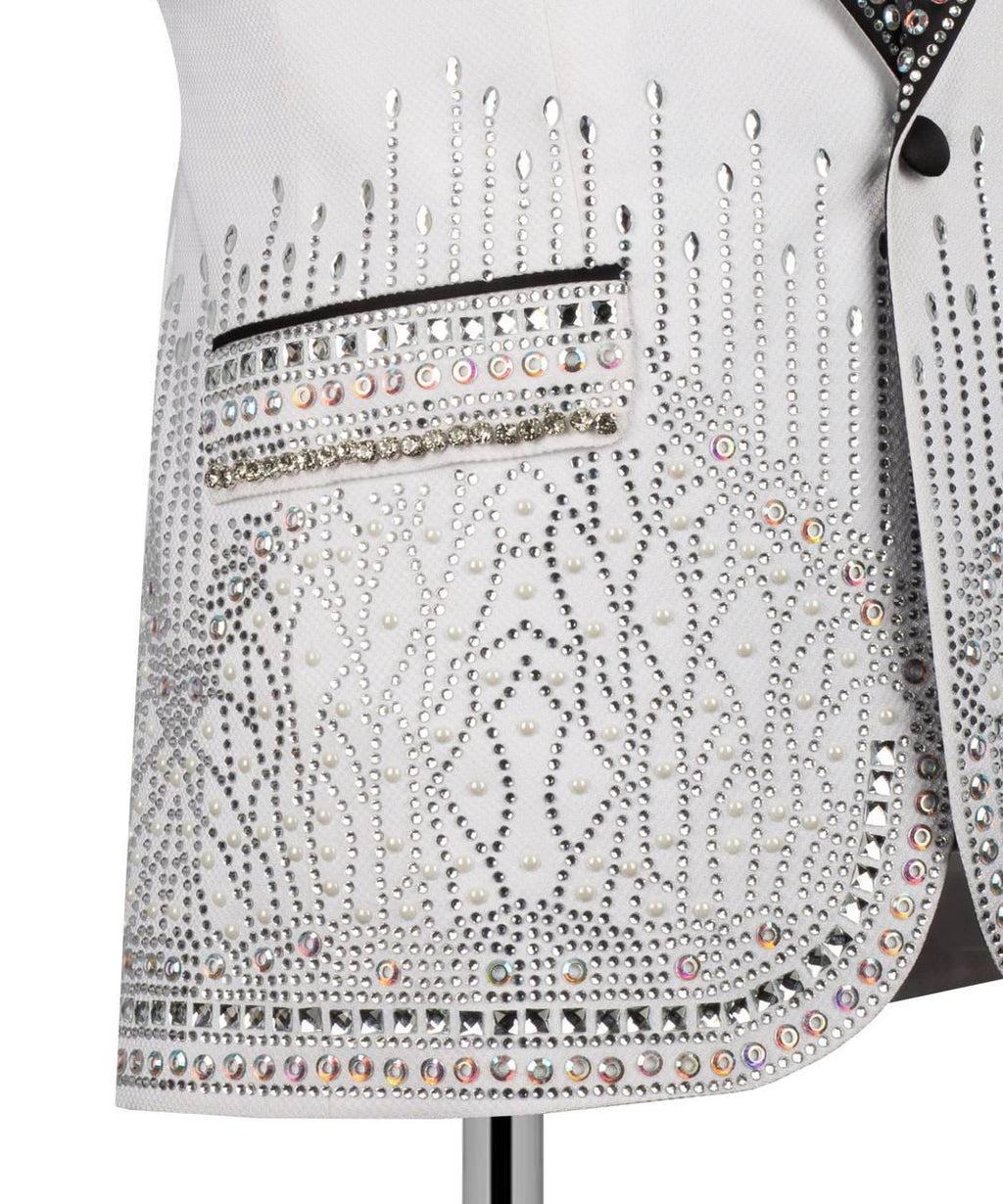 Close-up of a white embellished garment featuring intricate silver rhinestone and bead embroidery, a decorative pocket, and iridescent crystal accents.