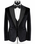 A black velvet tuxedo jacket displayed on a mannequin torso, styled with a white dress shirt, black bow tie, and matching black vest against a plain white background.