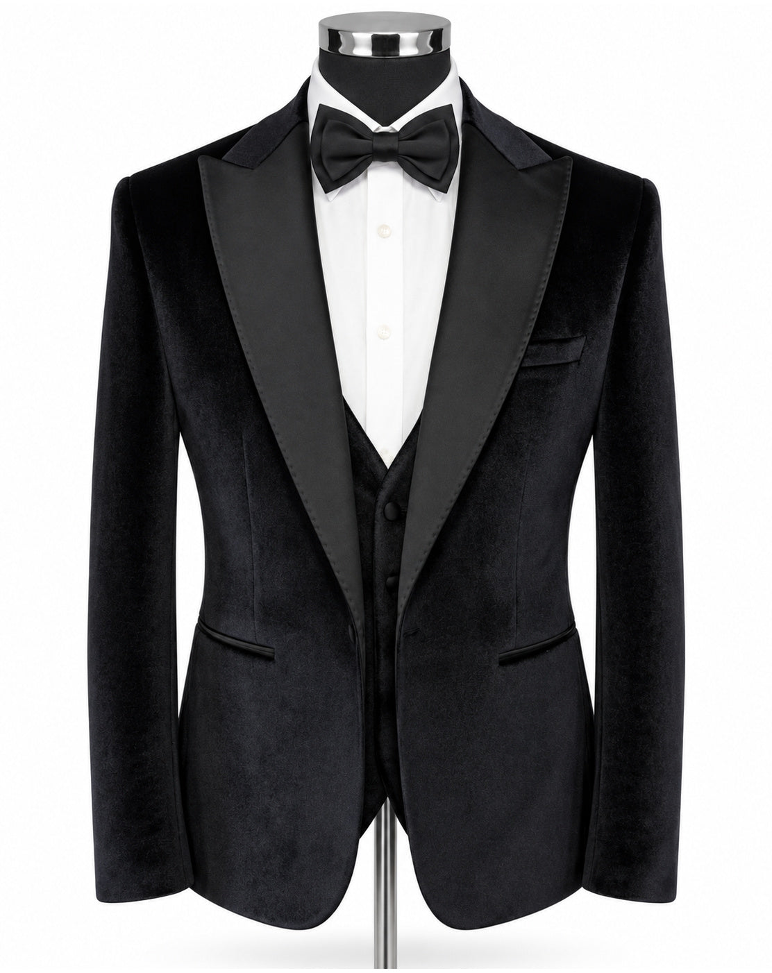 A black velvet tuxedo jacket displayed on a mannequin torso, styled with a white dress shirt, black bow tie, and matching black vest against a plain white background.