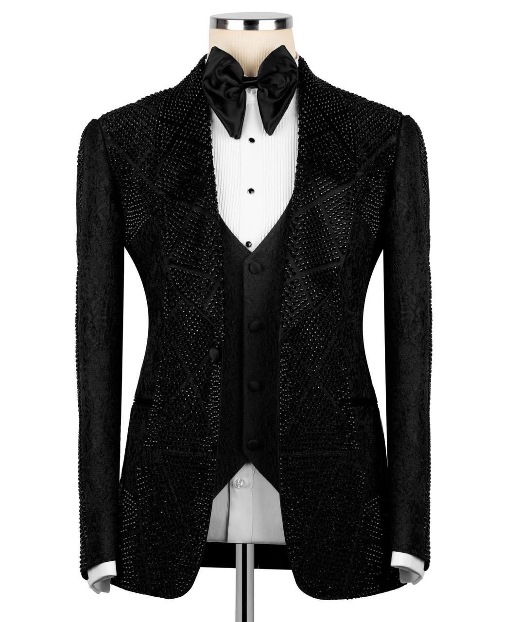A black beaded tuxedo jacket with a matching vest and bow tie, displayed on a mannequin torso over a white pleated shirt.