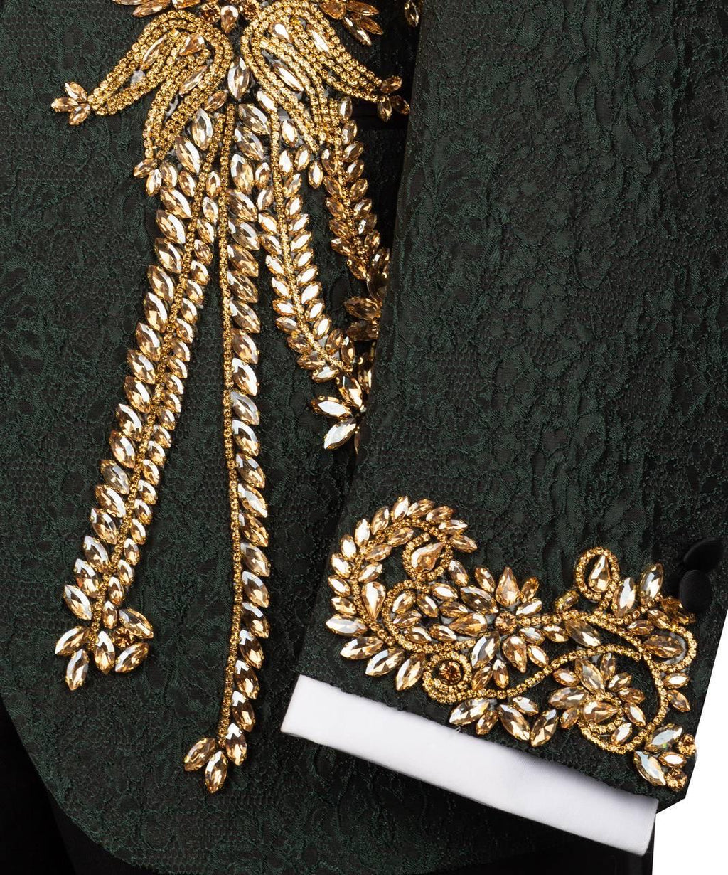 Close-up of a green fabric with gold embroidery on a dark background
